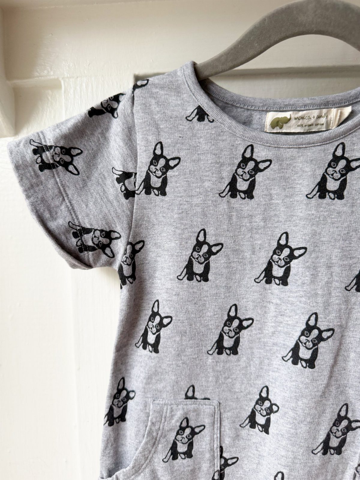 Grey infant t-shirt with black French Bulldog patterns hanging on a grey hanger