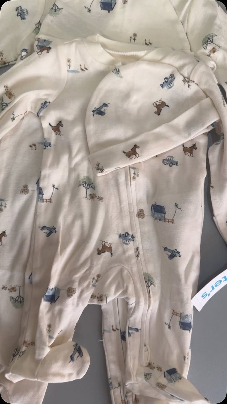 White cotton infant sleeper and matching beanie with a small animal and house print.