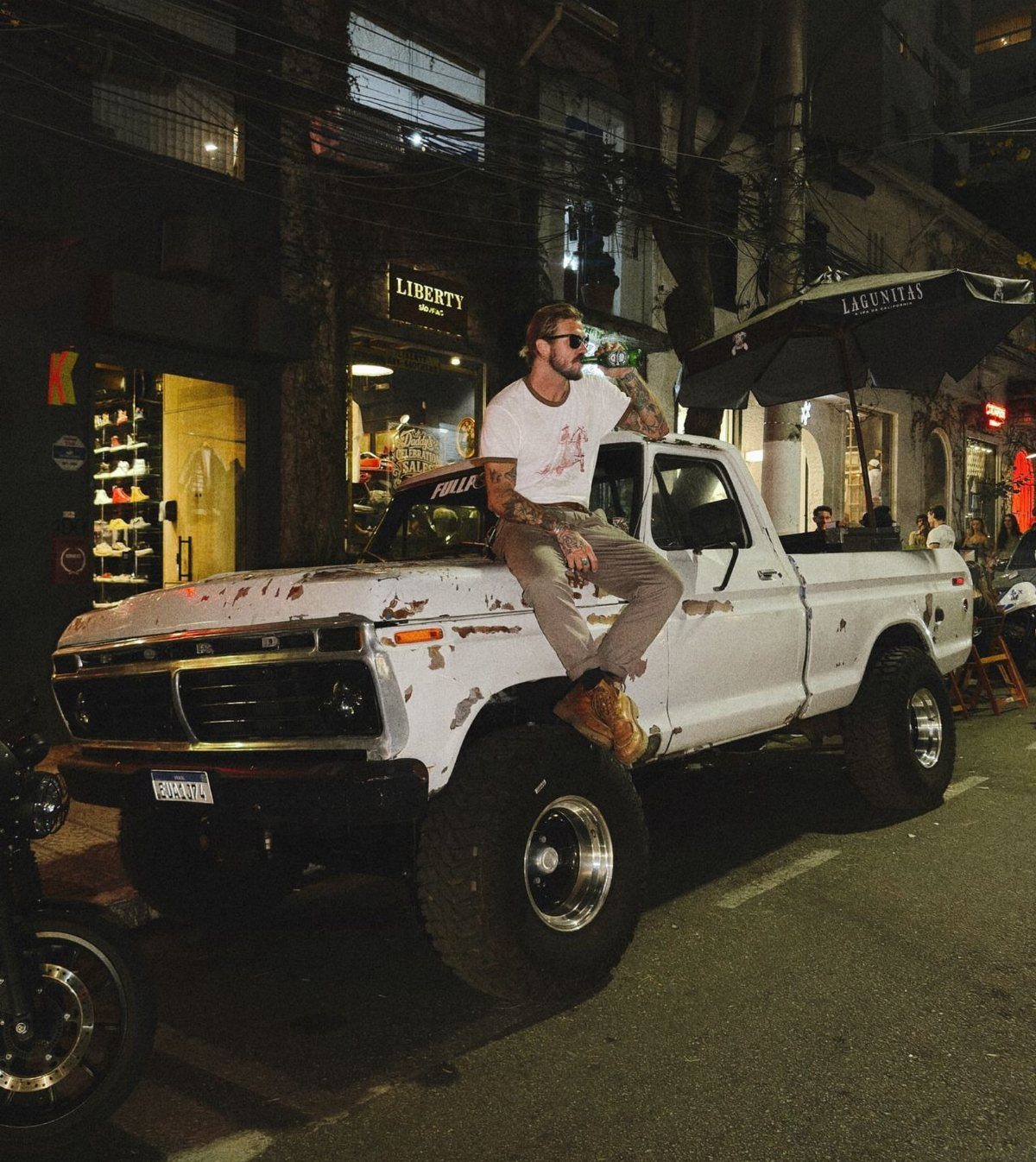 American Culture Clothing: 6 Ideas From Denim to Biker Jackets 4 Man in white t-shirt and khakis sitting on a vintage white Ford truck.
