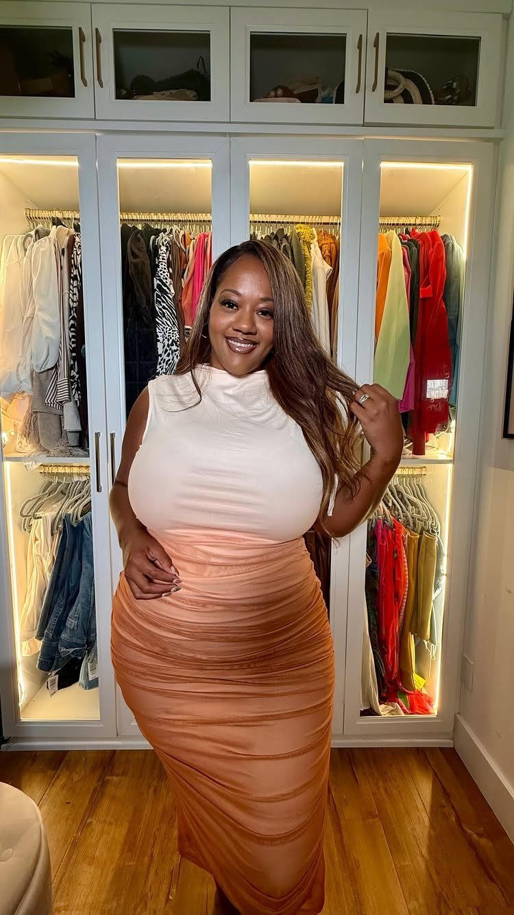 Plus-size woman wearing a white top and ruched copper skirt in a closet.