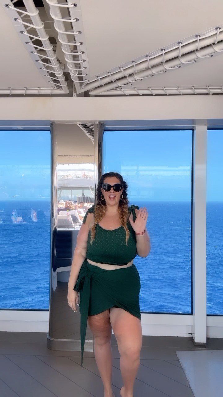 Plus-size woman in a dark green two-piece outfit on a cruise ship deck.