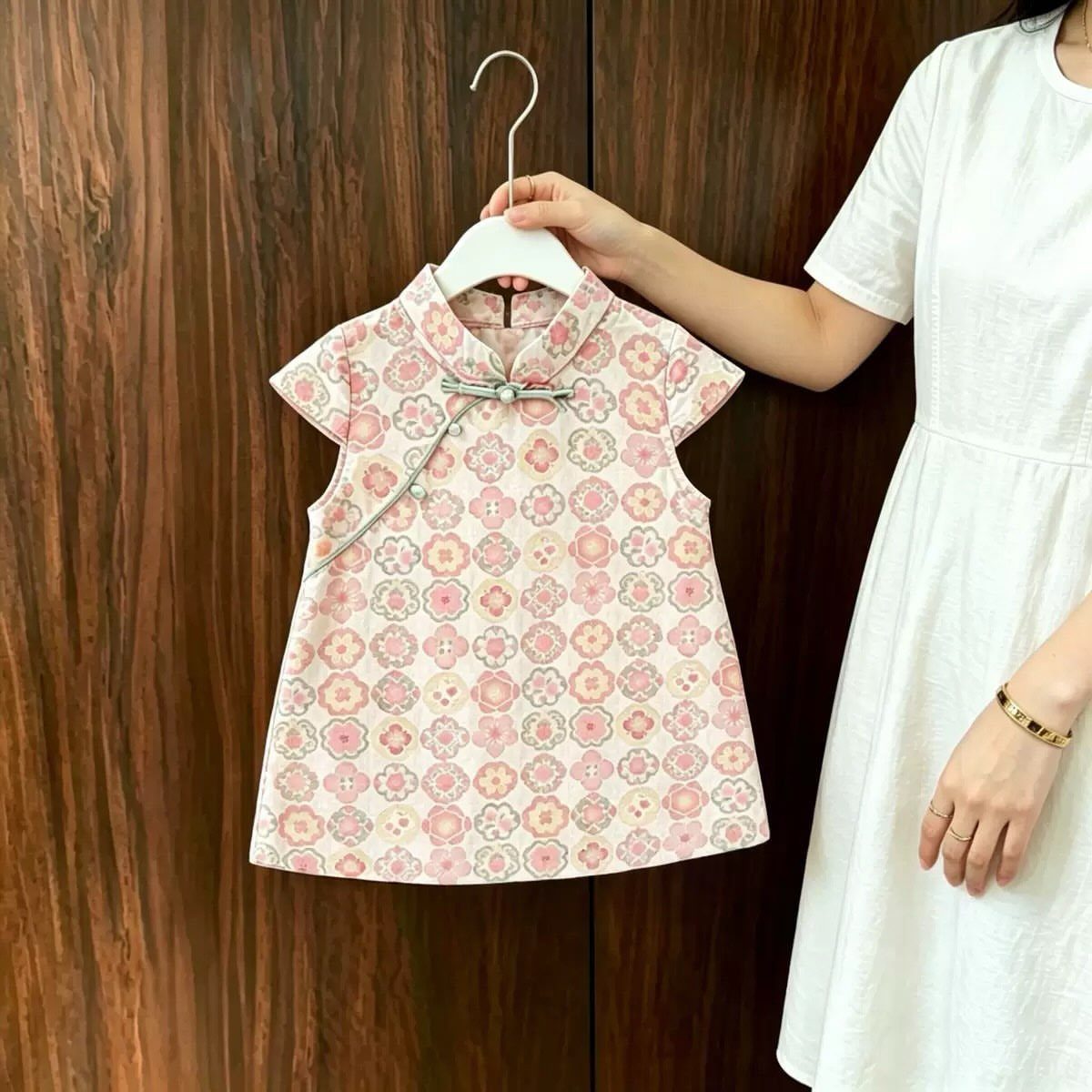 Chinese Infant Clothing: 7 Ideas for Baby Outfits 6 Pink and white patterned Chinese infant dress held on a white hanger.