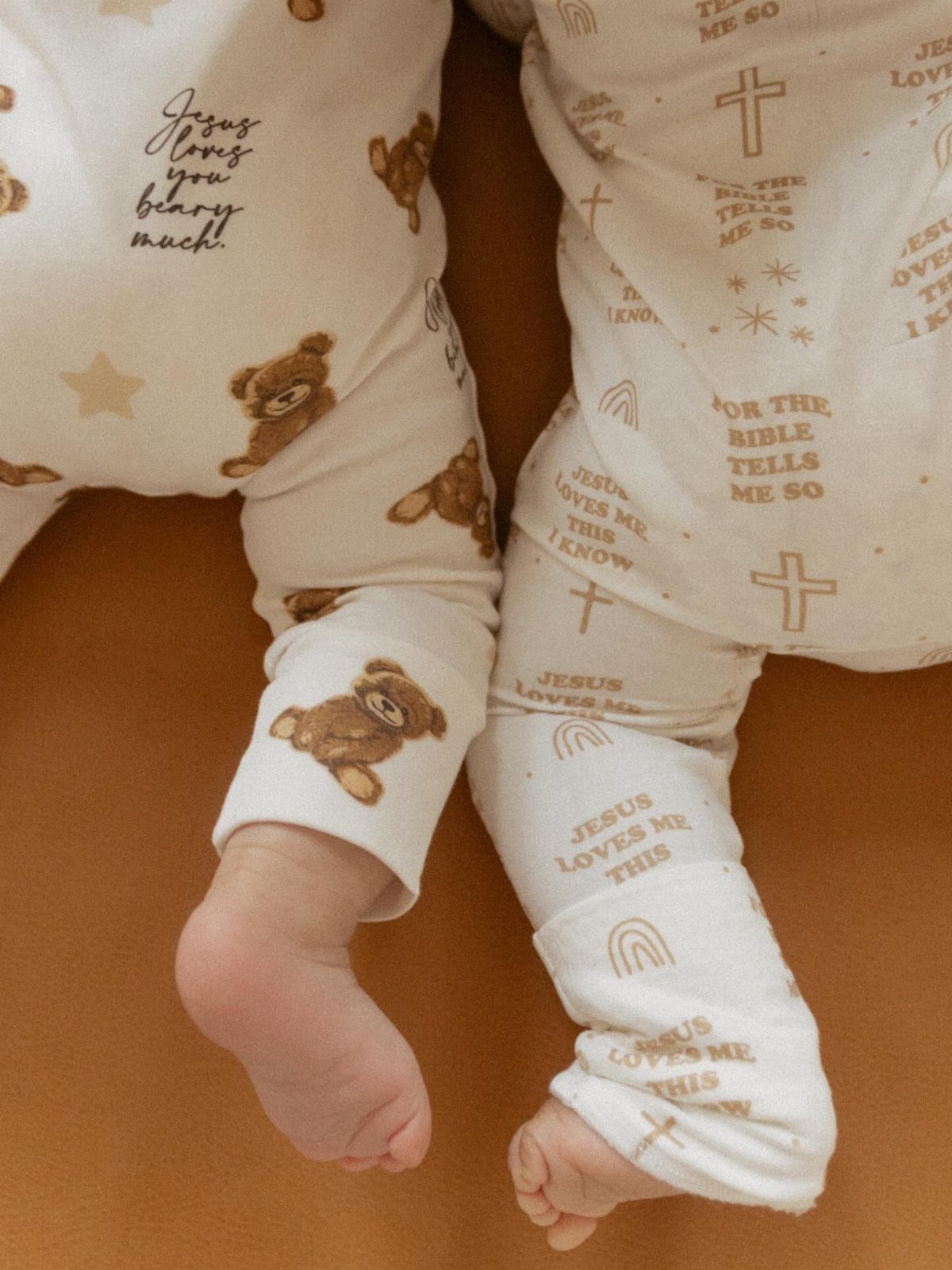 Christian Newborn Clothes for Baptism and Beyond: 5 Ideas 1 Infants wearing cream-colored Christian themed newborn clothes with teddy bears and crosses.