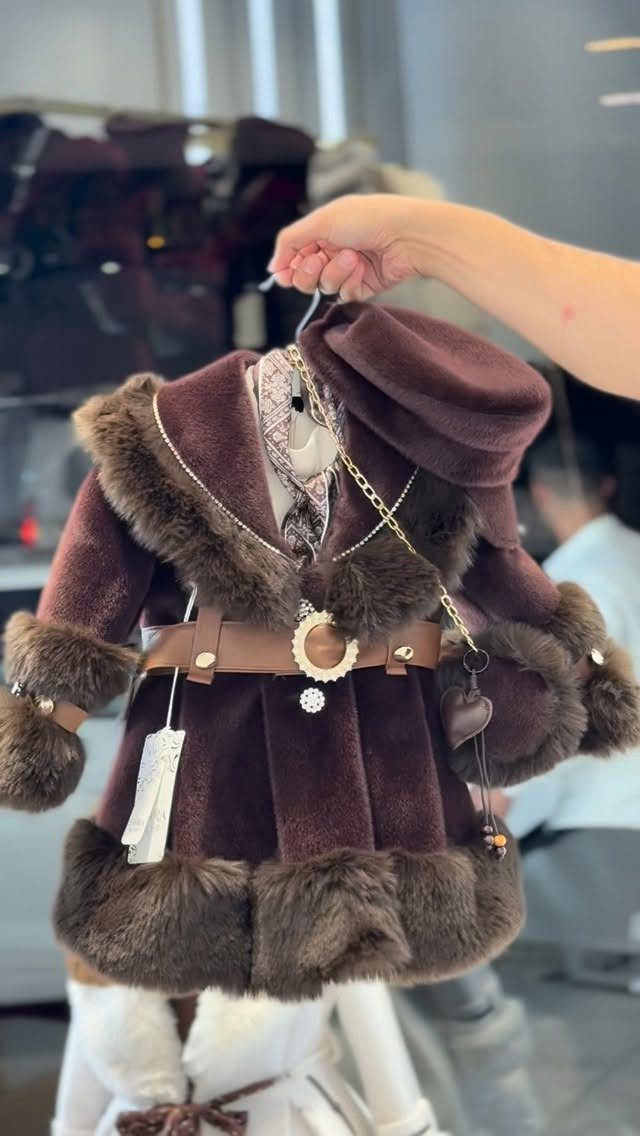 Burgundy velvet baby coat with brown fur trim and gold chain detail.
