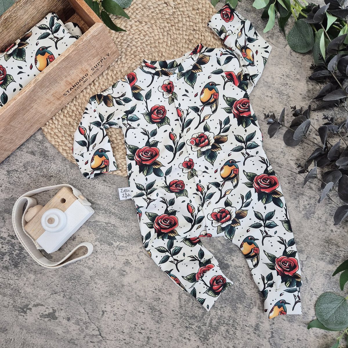Edgy Infant Clothing Ideas: 6 Looks from Skater to Goth 2 Infant jumpsuit with red rose and yellow bird print on concrete surface