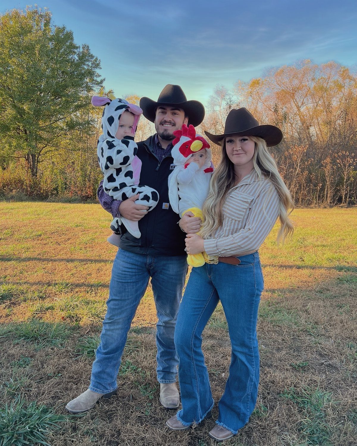 Family in cowboy attire with babies dressed as a cow and a chicken.