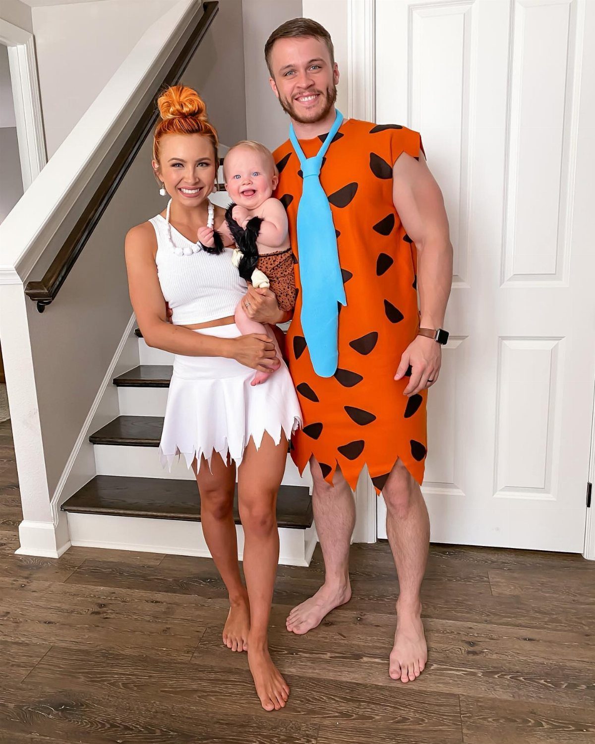 Family dressed as The Flintstones, including a baby in a leopard print outfit.