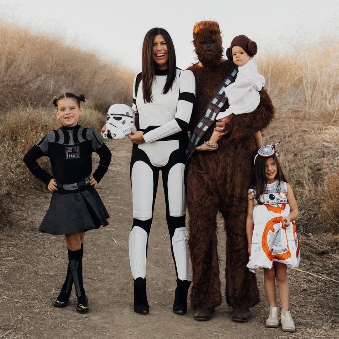 Family in Star Wars costumes including Stormtrooper, Chewbacca, Darth Vader, and BB-8 outfits.