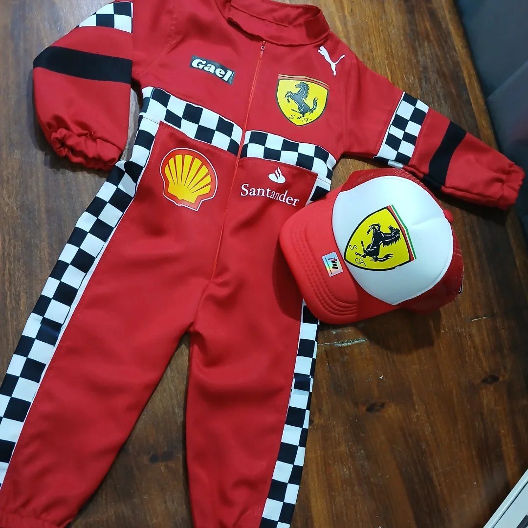Ferrari Newborn Clothes: 8 Ideas for Red Racing Looks 3 Red Ferrari infant racing jumpsuit and matching cap on a wooden table.