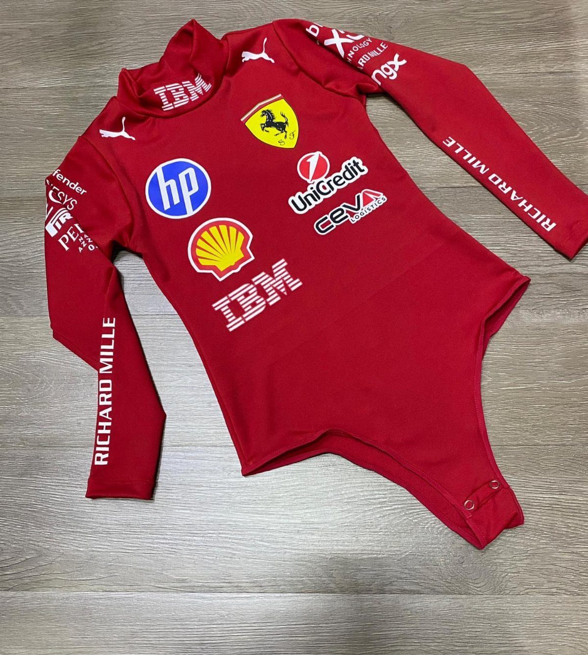 Ferrari Newborn Clothes: 8 Ideas for Red Racing Looks 4 Red long-sleeve baby bodysuit with Ferrari and sponsor logos on grey wood floor