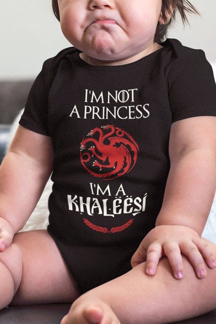 Baby wearing a black onesie with Khaleesi text and a red dragon emblem.
