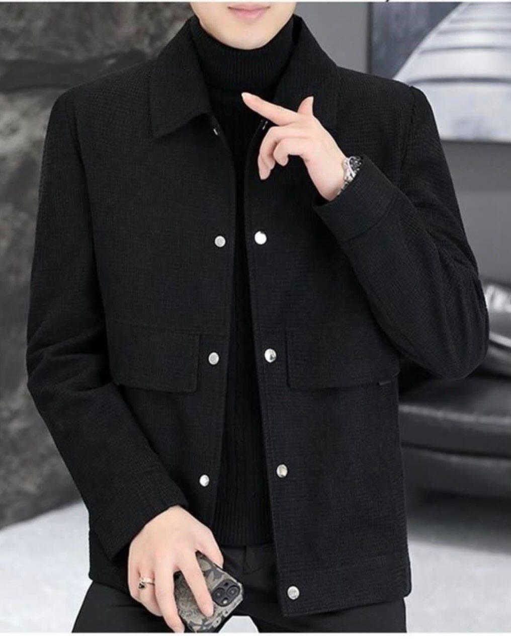 15 Gender Neutral Clothing Ideas for Everyday Style 14 Person wearing a black turtleneck and black button-up jacket in an indoor setting.