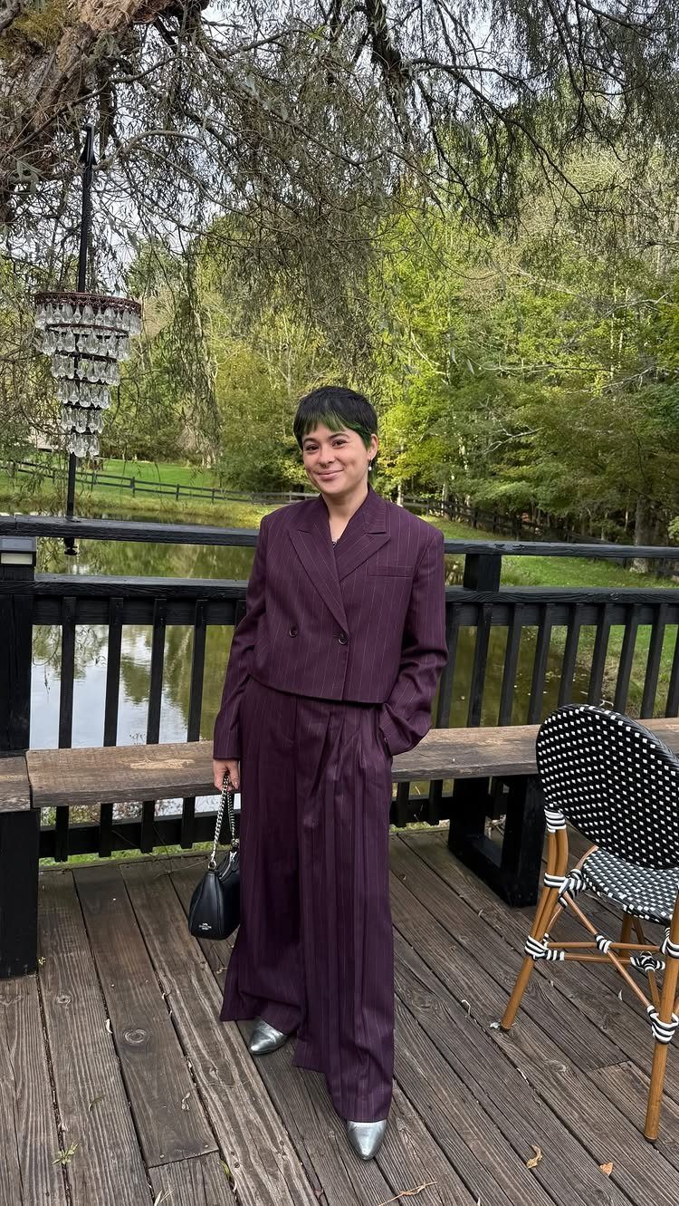 15 Gender Neutral Clothing Ideas for Everyday Style 4 Person in an oversized purple suit standing on a wooden deck by a pond