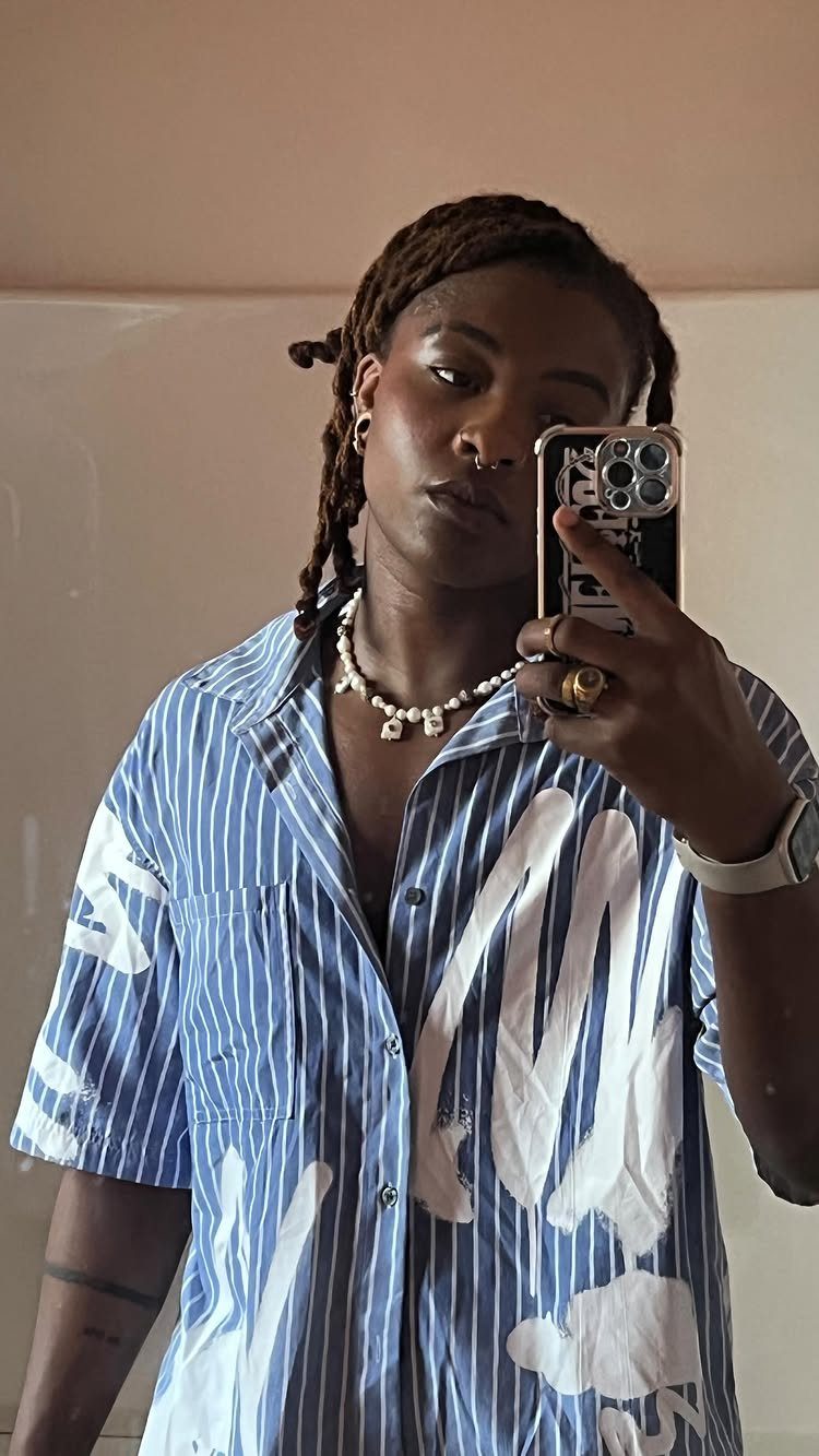 15 Gender Neutral Clothing Ideas for Everyday Style 15 Person wearing a blue and white striped shirt with abstract white paint designs.