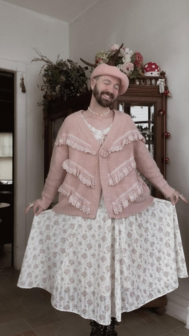 15 Gender Neutral Clothing Ideas for Everyday Style 7 Bearded man wearing a pink beret, ruffled cardigan, and long floral skirt.
