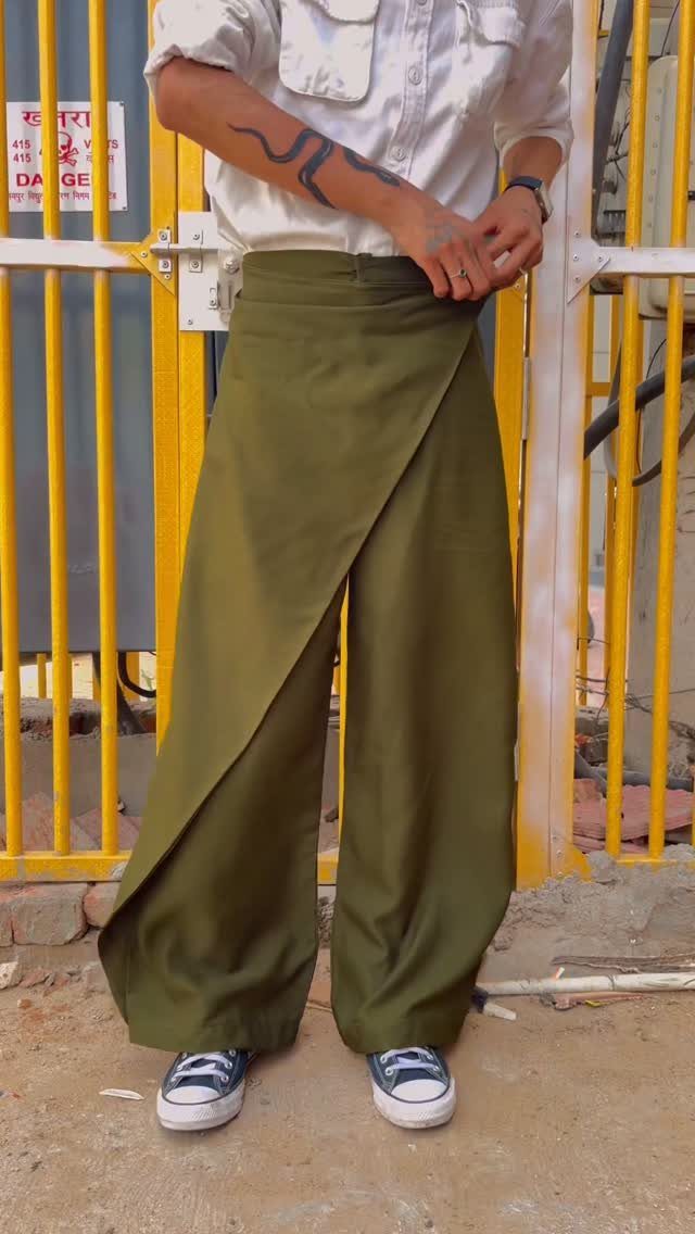 15 Gender Neutral Clothing Ideas for Everyday Style 5 Person wearing a white button-up shirt and olive green wide-leg wrap pants.