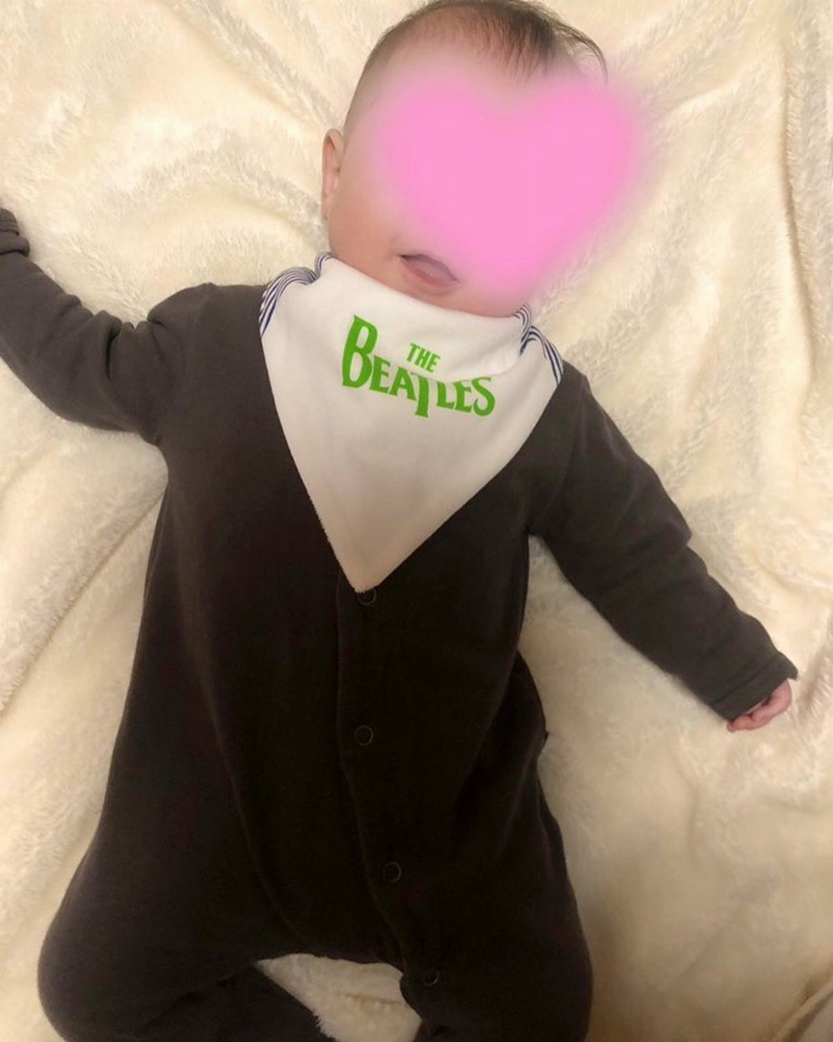 Infant Beatles Clothing: 3 Ideas for Onesies, Bibs and More 3 Infant in a grey romper wearing a white Beatles branded baby bib.