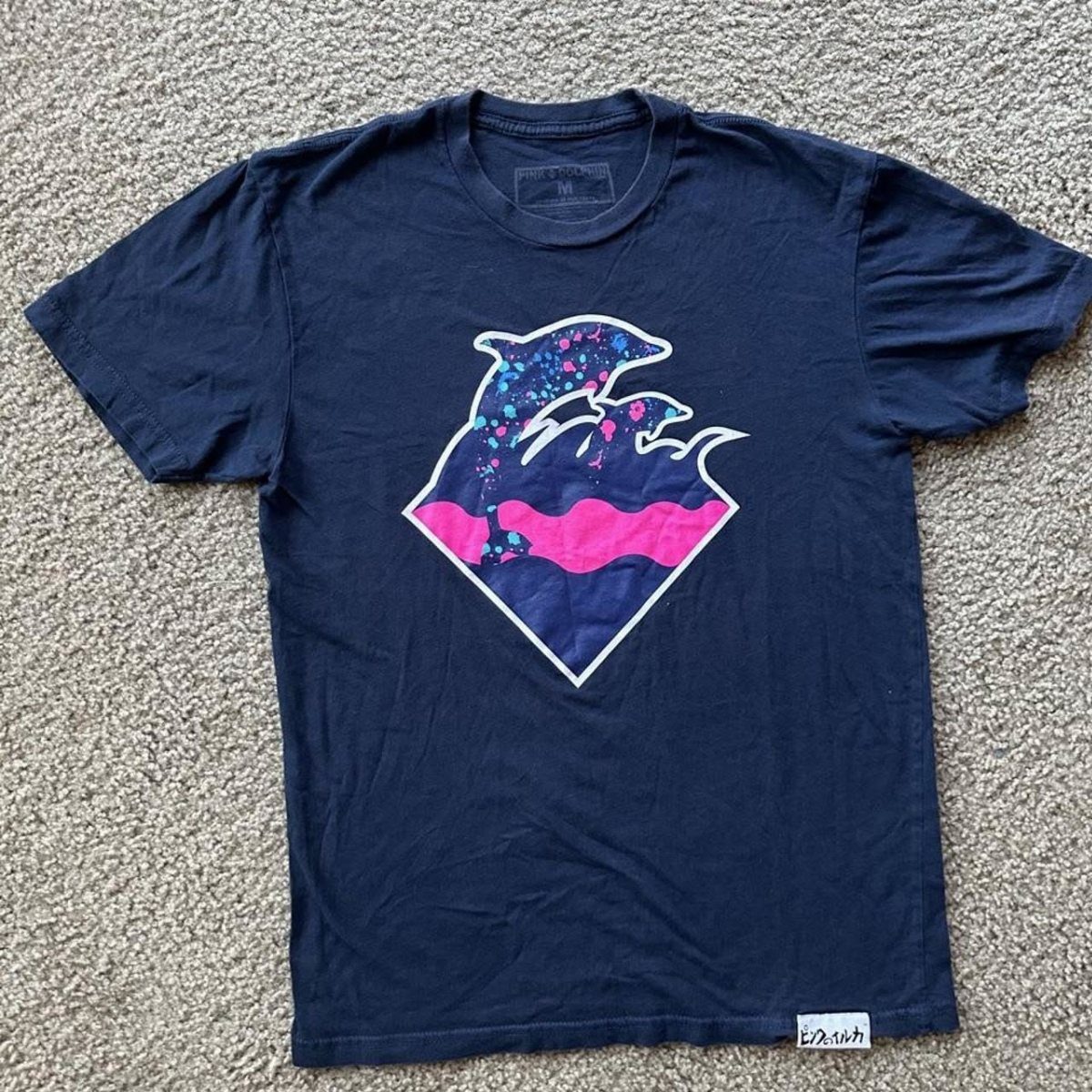 Pink Dolphin Clothing: 7 Ideas for Hoodies, Hats and More 2 Navy blue t-shirt with a diamond graphic featuring dolphins and pink accents.
