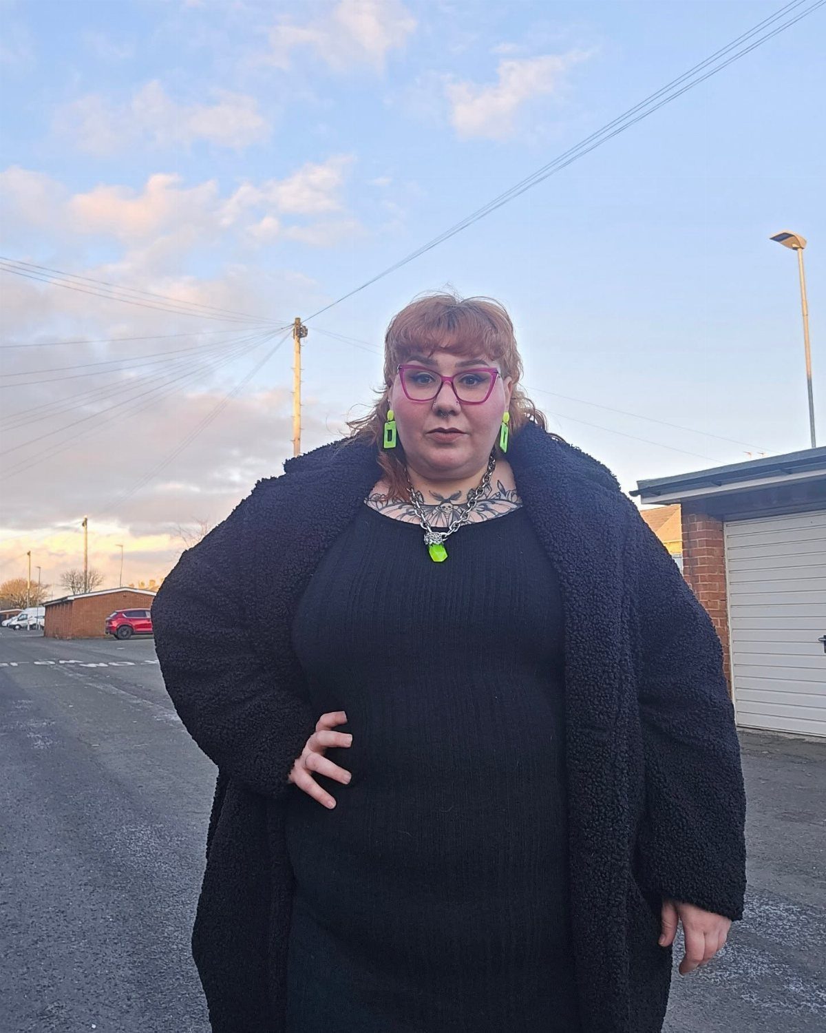 Woman wearing a long textured black gothic coat and black dress outdoors.