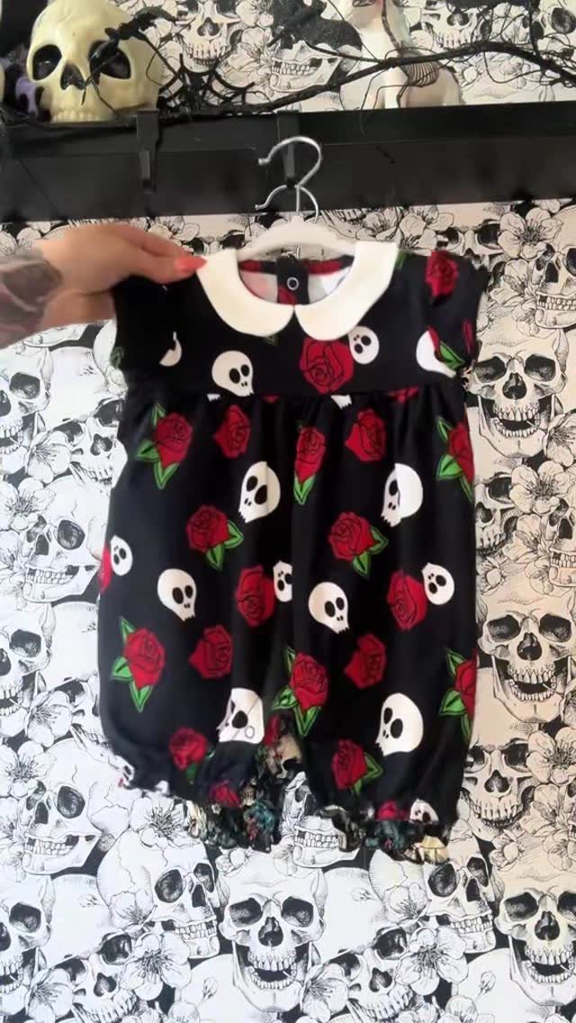 10 Rockabilly Infant Clothing Ideas for Little Rock Stars 2 Black infant romper with white skulls and red roses on skull wallpaper