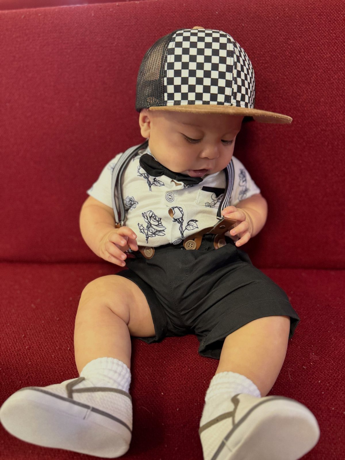 10 Rockabilly Infant Clothing Ideas for Little Rock Stars 4 Infant wearing a checkered hat, floral shirt, bow tie, and black shorts.