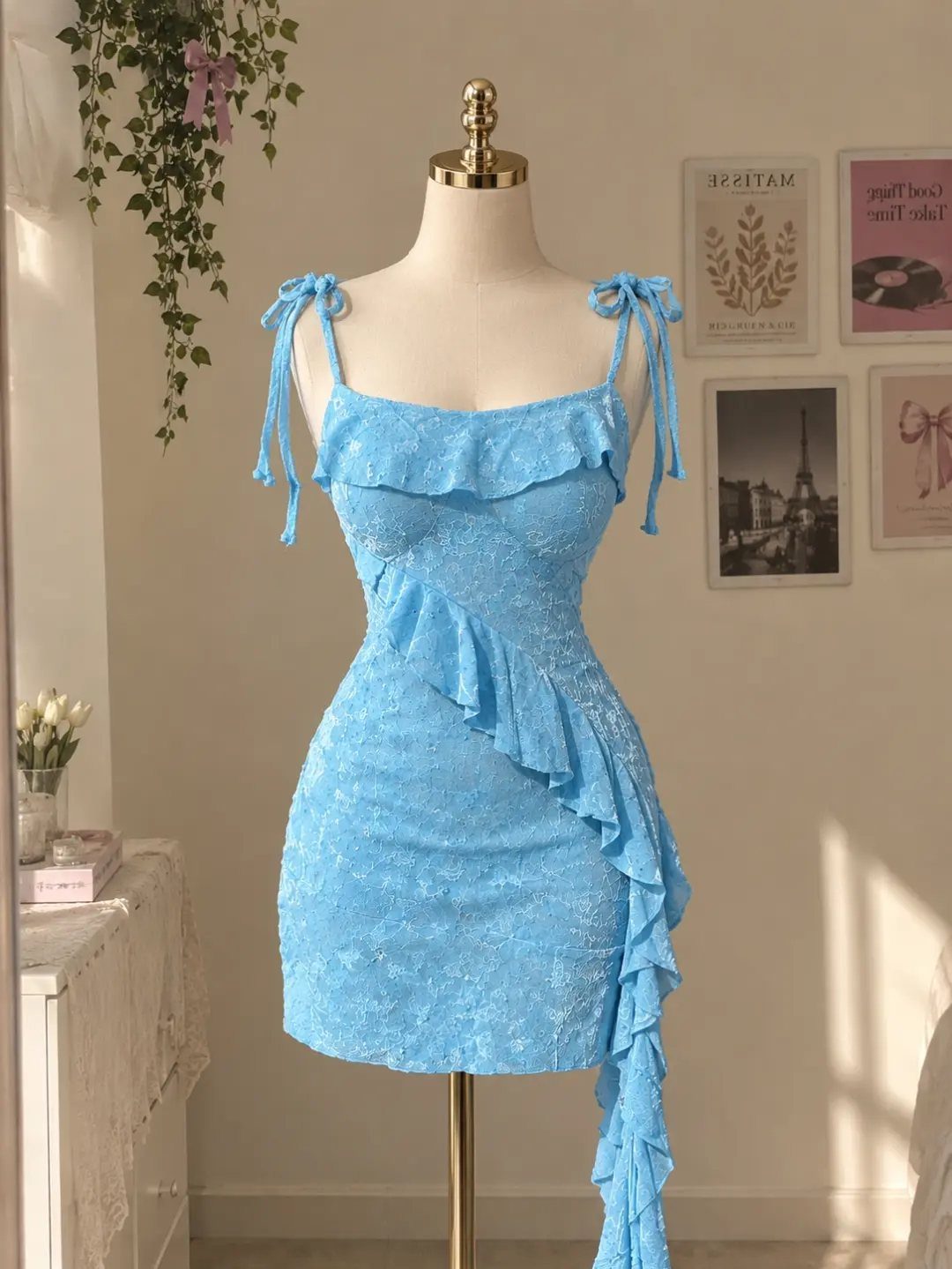 Light blue ruffled mini dress with shoulder ties on a mannequin in a room