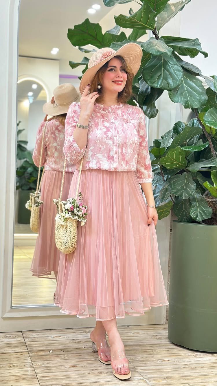 Woman in pink floral lace top and tulle skirt wearing a straw hat