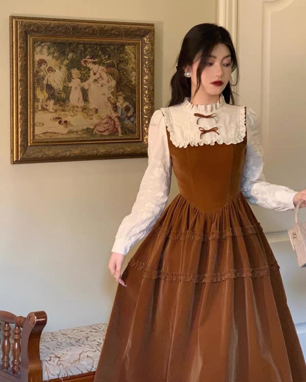 Woman in a brown Victorian-style dress and white blouse standing indoors.